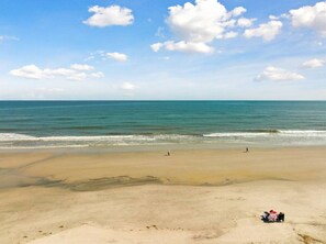 A beach with a clear sky, calm sea, and a few people walking. - BEACH BLOCK ★ PARKING ★ MODERN DECOR ★ PORCH (Brigantine)