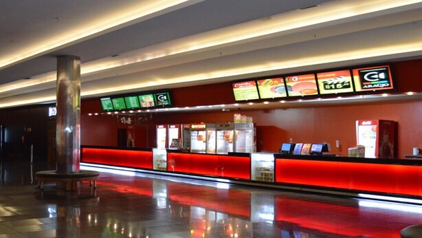 A modern hotel lobby with a red reception desk, digital menu boards, and a polished floor. - Casa 1 (Rio de Janeiro)