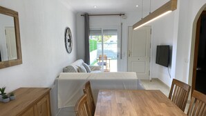 Una sala de estar moderna con un sofá, una mesa de comedor de madera y sillas.