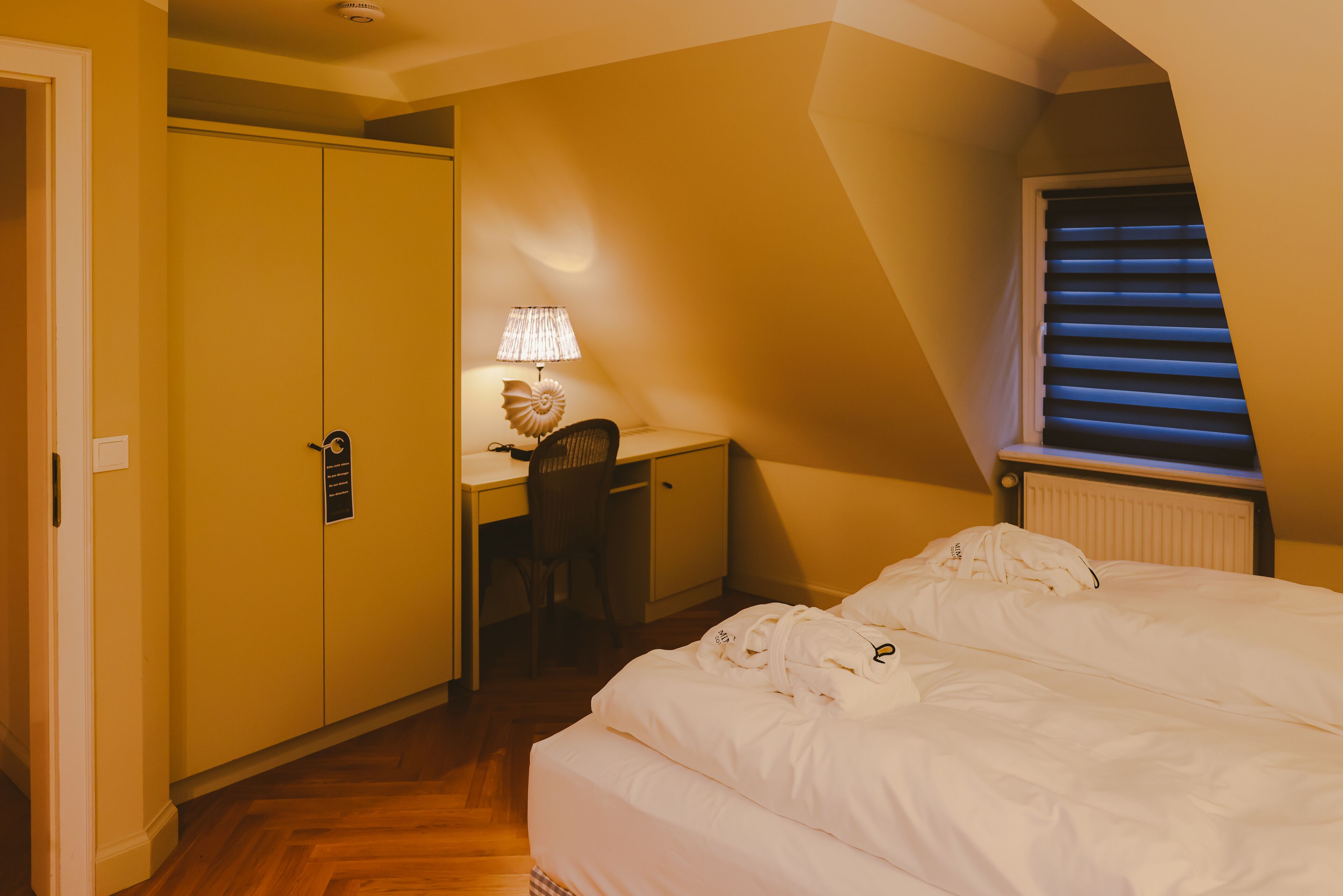 Une chambre à coucher comprenant un lit, un bureau, une chaise et une armoire.