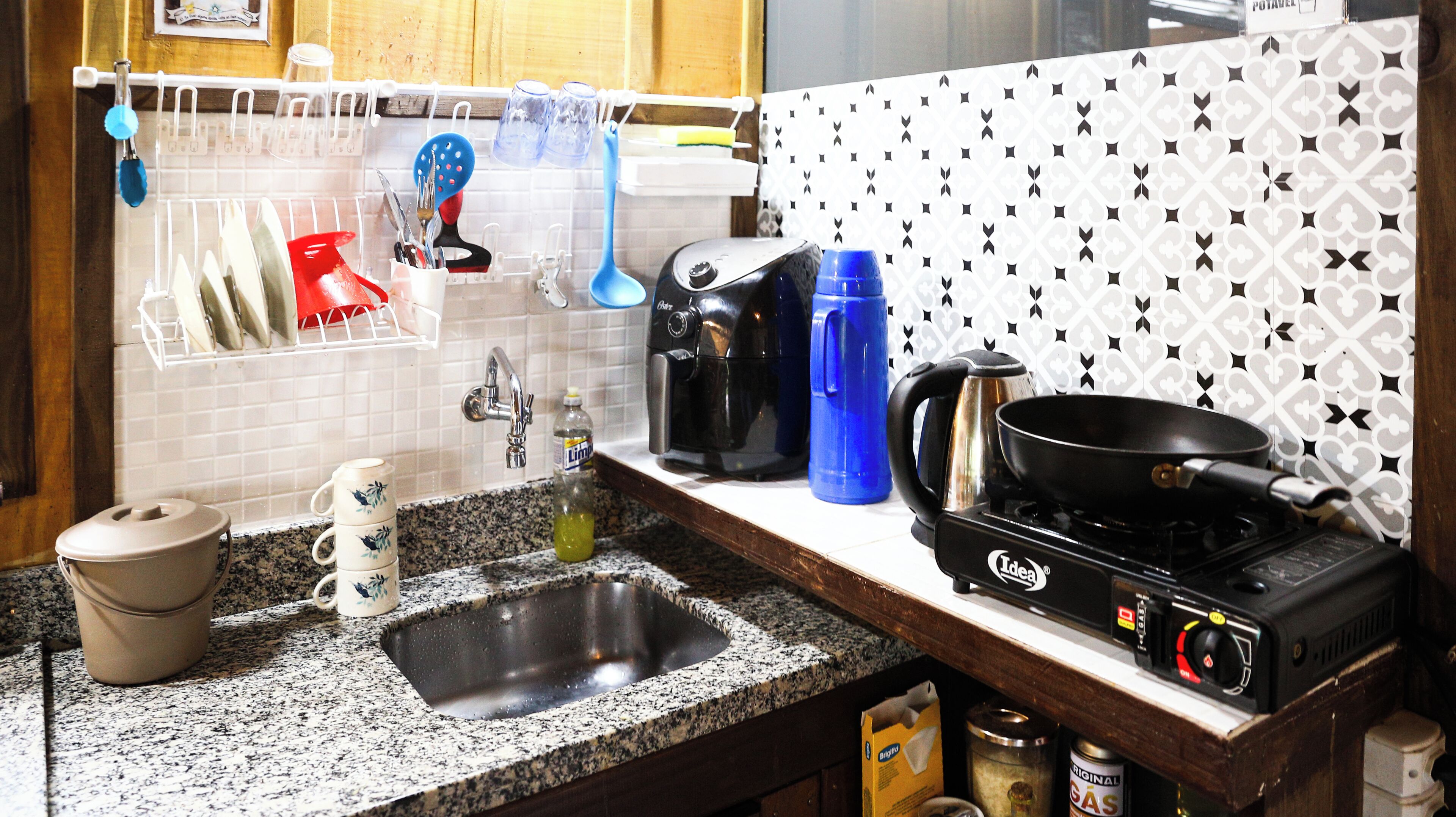Una cucina con lavello, fornelli, macchina da caffè e utensili.