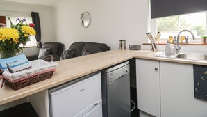 Een kleine keuken met een vaatwasser, een spoelbak en een raam met uitzicht.