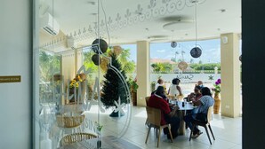 A restaurant with a glass wall, indoor plants, and a view of the outdoors.
