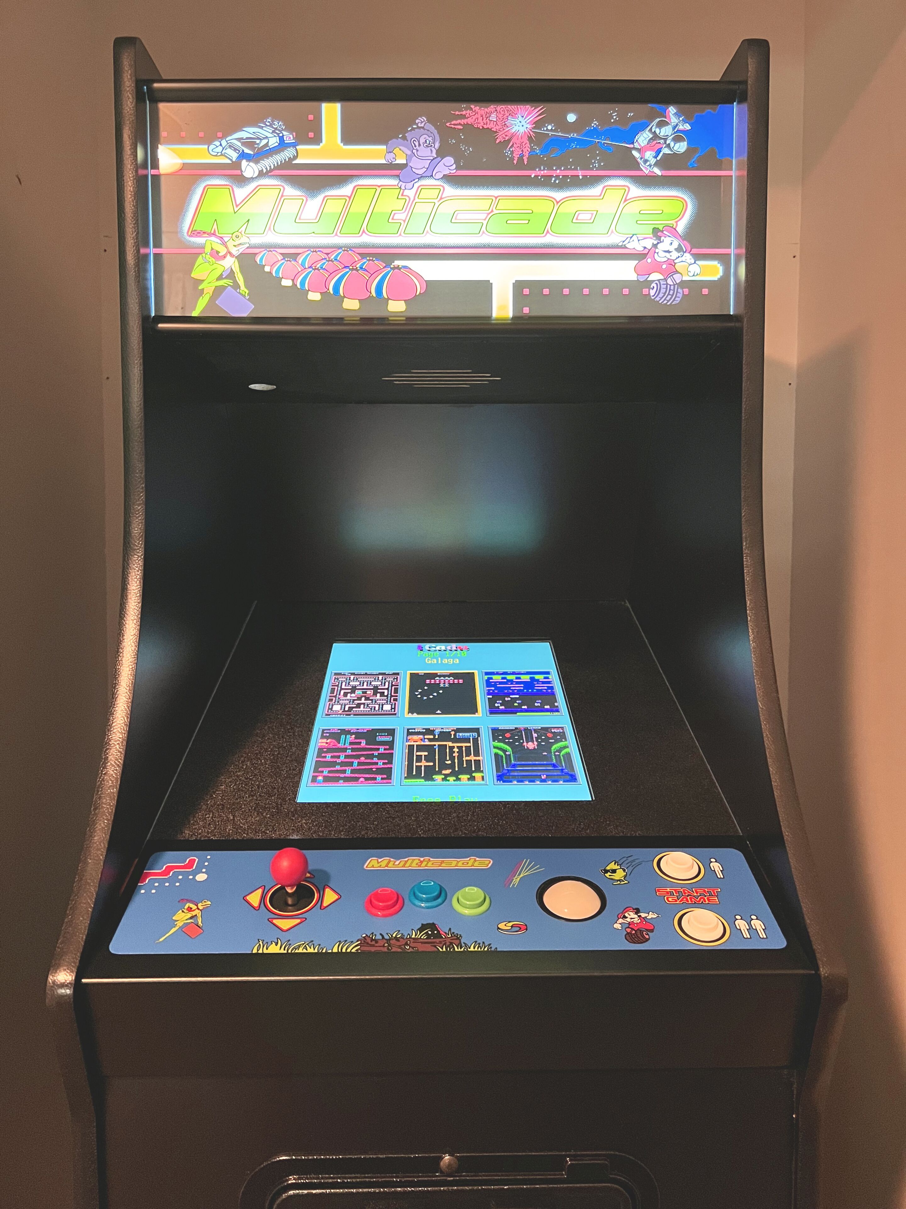 Vanha pelihalliin tarkoitettu peliautomaatti, jonka näytöllä näkyy teksti ”Multicade” ja erilaisia pelivaihtoehtoja.