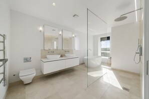 A modern bathroom with a glass-enclosed shower, a large mirror, and a white sink. - Modern Home with Stunning Gannel Estuary Views (Newquay)