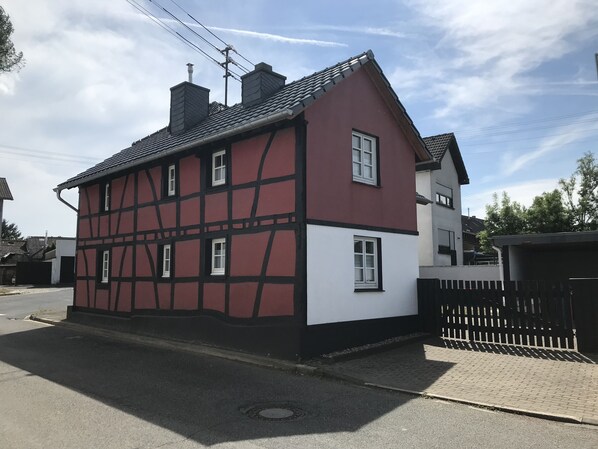 Un bâtiment à deux étages, doté d’une façade rouge et blanche, de nombreuses fenêtres et d’une clôture noire à l’avant.