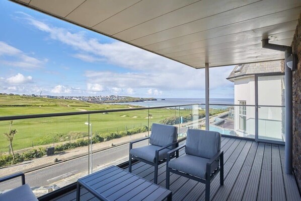 Un balcon avec vue sur un terrain de golf et sur une étendue d’eau.