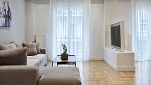 Un salon moderne avec un canapé, une table basse et un téléviseur à écran plat.