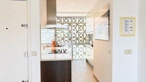 A modern kitchen with a central island, a decorative partition, and a wall-mounted menu. - Apartment with terrace, swimming pool and private parking on the Costa Brava (Palafrugell)