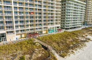 A multi-story hotel with balconies, a pool area, and a beach access walkway. - Enjoy Breath-taking Sunsets & Endless Ocean Views at Soul Happy Majestic Beach! (Panama City Beach)