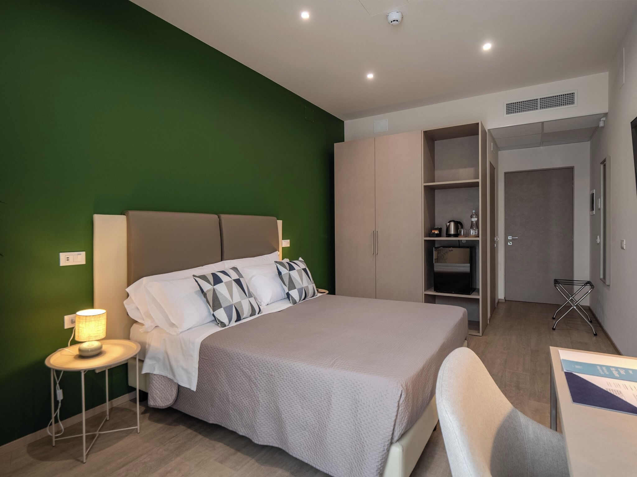Un dormitorio moderno con cama, mesita de noche y armario.