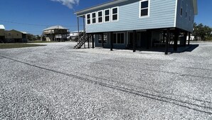 A two-story building with a flat roof and a covered front porch. - Flying Fish Yellow Fin-Beach Access-Island Realty (Grand Isle)
