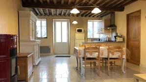 Une cuisine équipée d’une table à manger, de chaises, d’un four à micro-ondes et d’une cuisinière.
