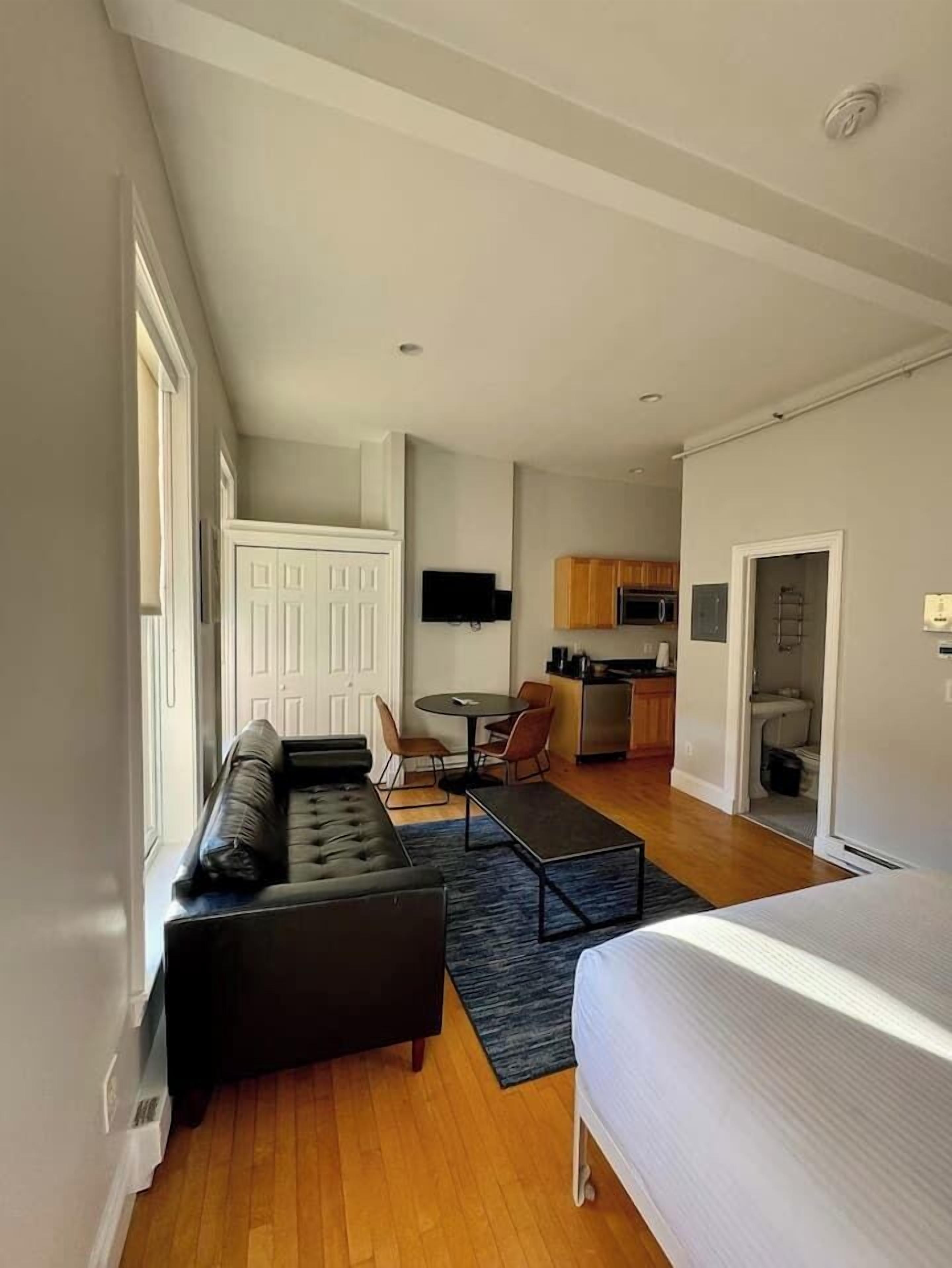 Un apartamento moderno con sala de estar, kitchenette y comedor.