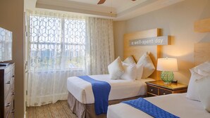 A hotel room with two beds, a large window with a view, a sign on the wall, and a lamp on the nightstand. - Adventure Park Vacation 1 BR Condo with Tropical Pool (Orlando)