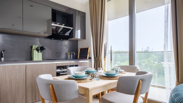 A modern kitchen with a dining area, large windows, and a view of the city. - As Maslak by NewInn (Sariyer)