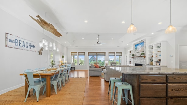 A spacious kitchen with a large island, wooden dining table, and light blue chairs. - Bonny Blue:  Gorgeous SGI Home, Pet Friendly, Private Pool,  Sleeps 14 (St. George Island)