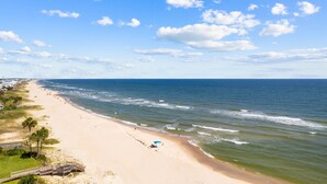 A beach with a wooden walkway, a few umbrellas, and a clear view of the ocean. - Bonny Blue:  Gorgeous SGI Home, Pet Friendly, Private Pool,  Sleeps 14 (St. George Island)