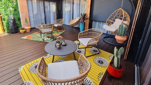 A wooden deck with wicker furniture, a round table, and potted cacti. - Charming town center residence with terrace and view of the Canigou mountains (Thuir)