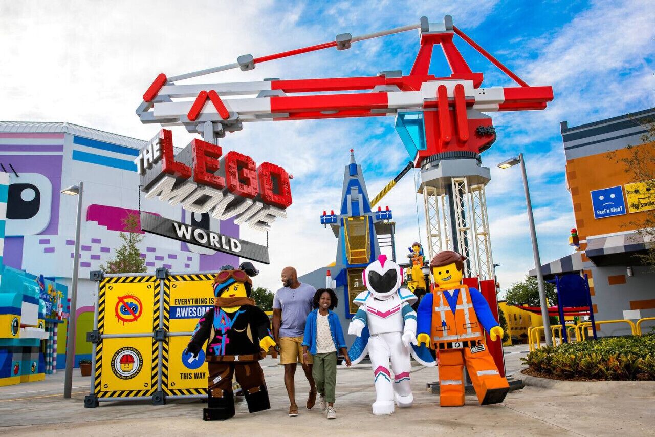 A LEGO-themed area with a large LEGO sign, a crane structure, and LEGO figures.