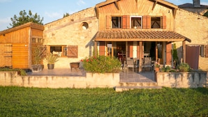 A stone house with a tiled roof, wooden shutters, and a covered patio area with outdoor seating. - Spacious Villa for 6-8 People plus 2 Babies with Exclusive Pool (Caubon-Saint-Sauveur)