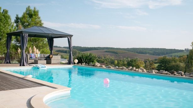 A swimming pool with a gazebo and outdoor seating area, surrounded by a landscaped garden and hills in the background. - Spacious Villa for 6-8 People plus 2 Babies with Exclusive Pool (Caubon-Saint-Sauveur)