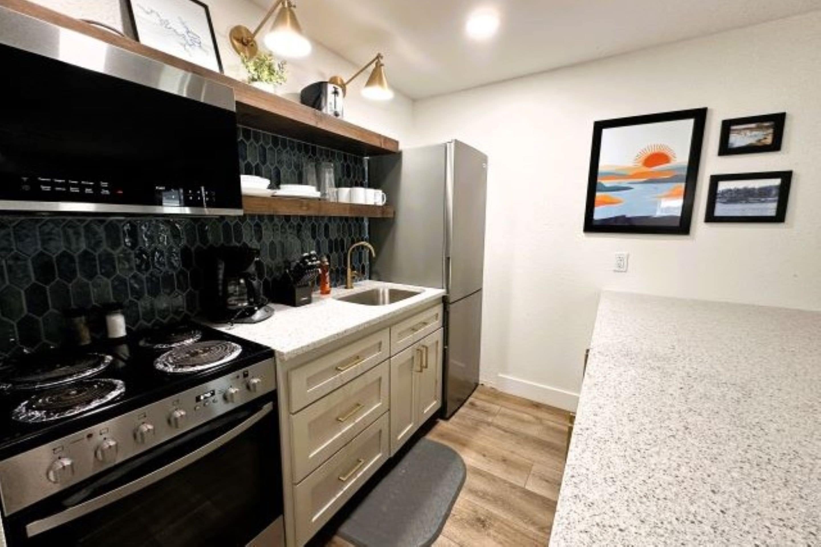 A modern kitchen with a stainless steel stove, a refrigerator, and a countertop.