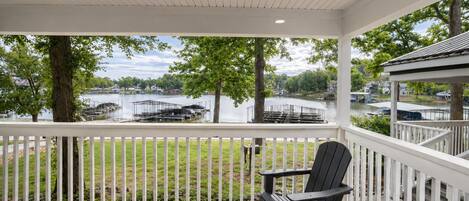 A covered outdoor area with a view of a lake, dock, and boats.