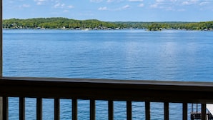 A view of a lake with a wooden deck in the foreground. - Alhonna Resort LLC (Lake Ozark)