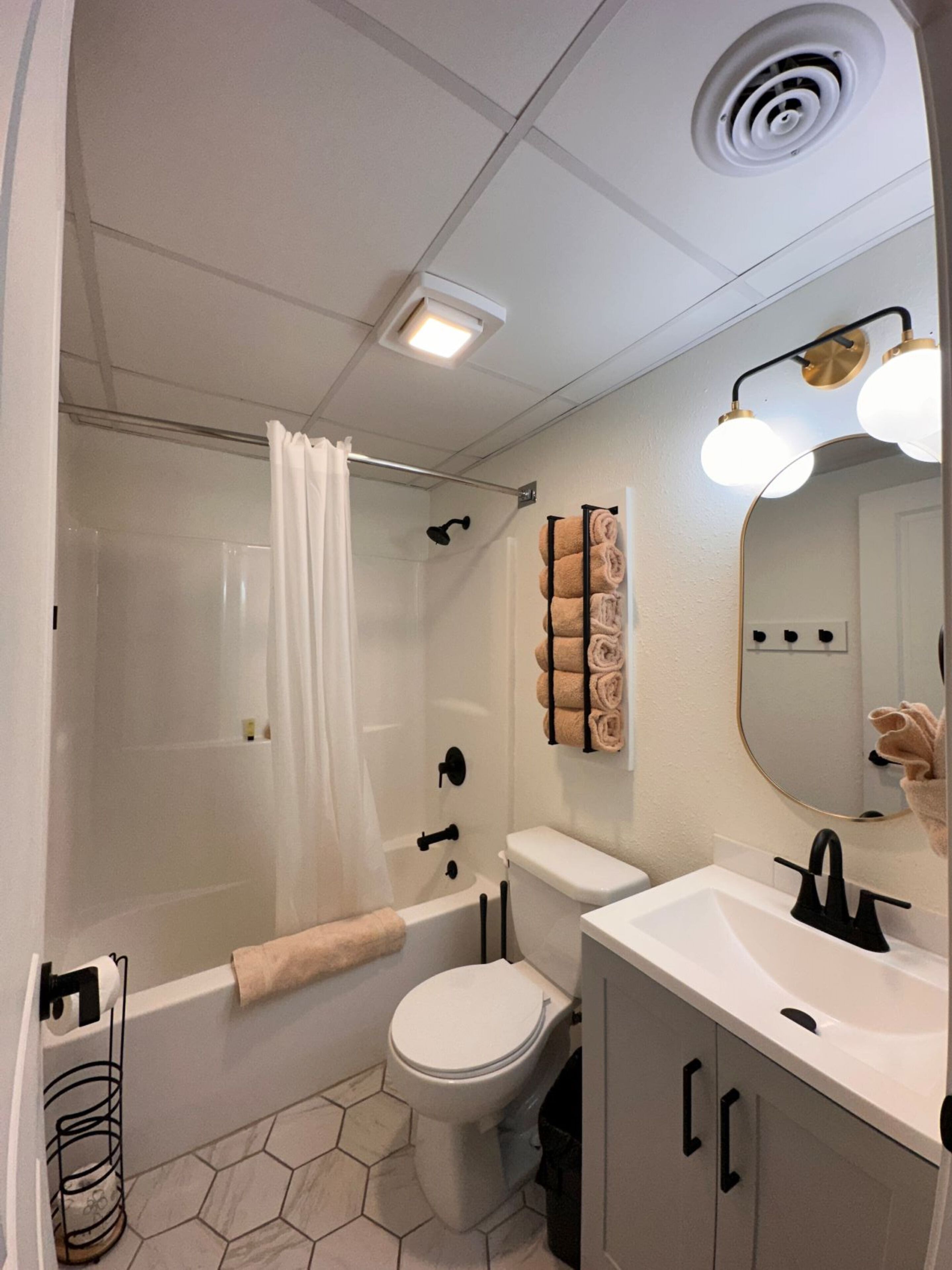 A modern bathroom with a shower, toilet, and sink.
