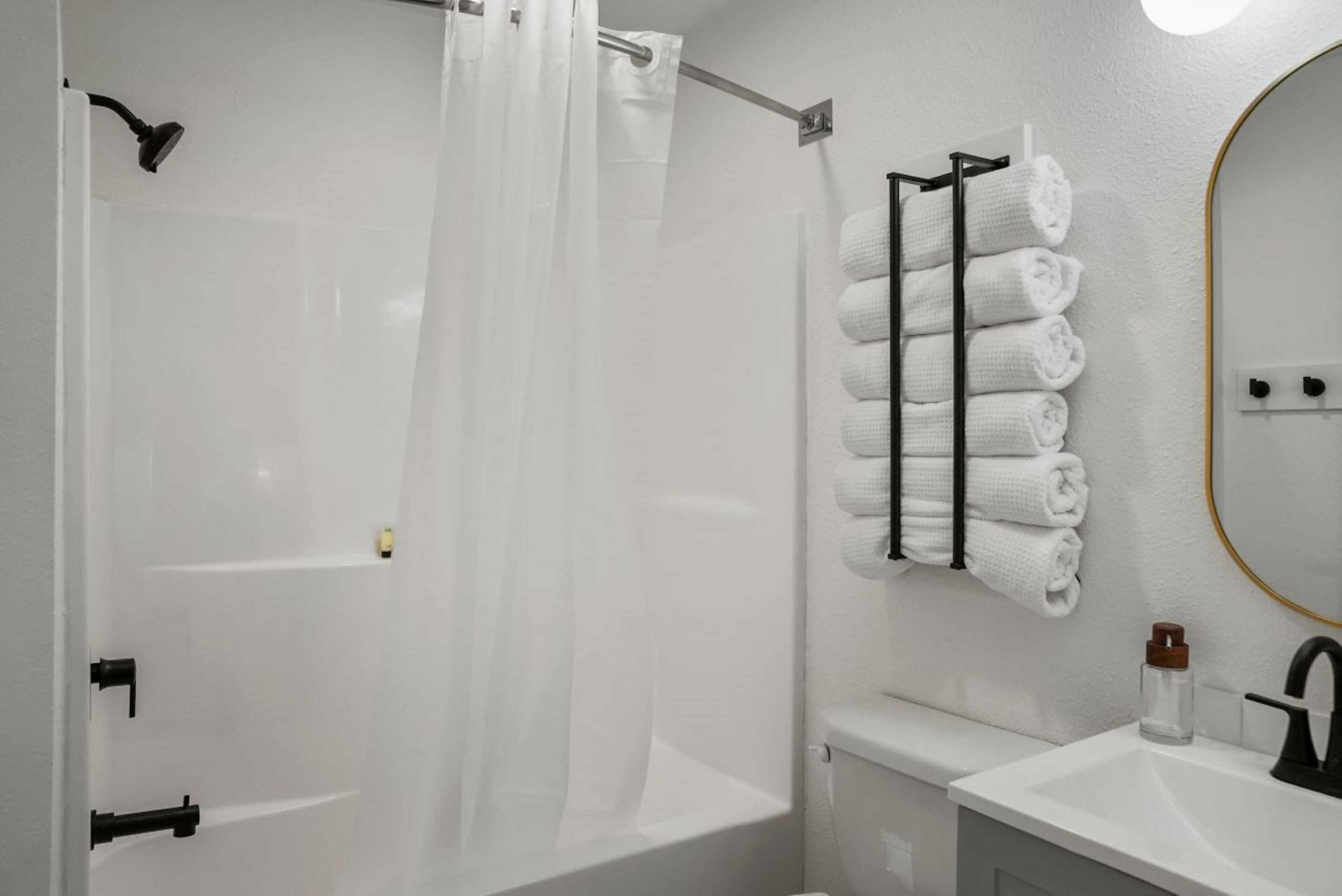 A modern bathroom with a shower, a toilet, and a sink.