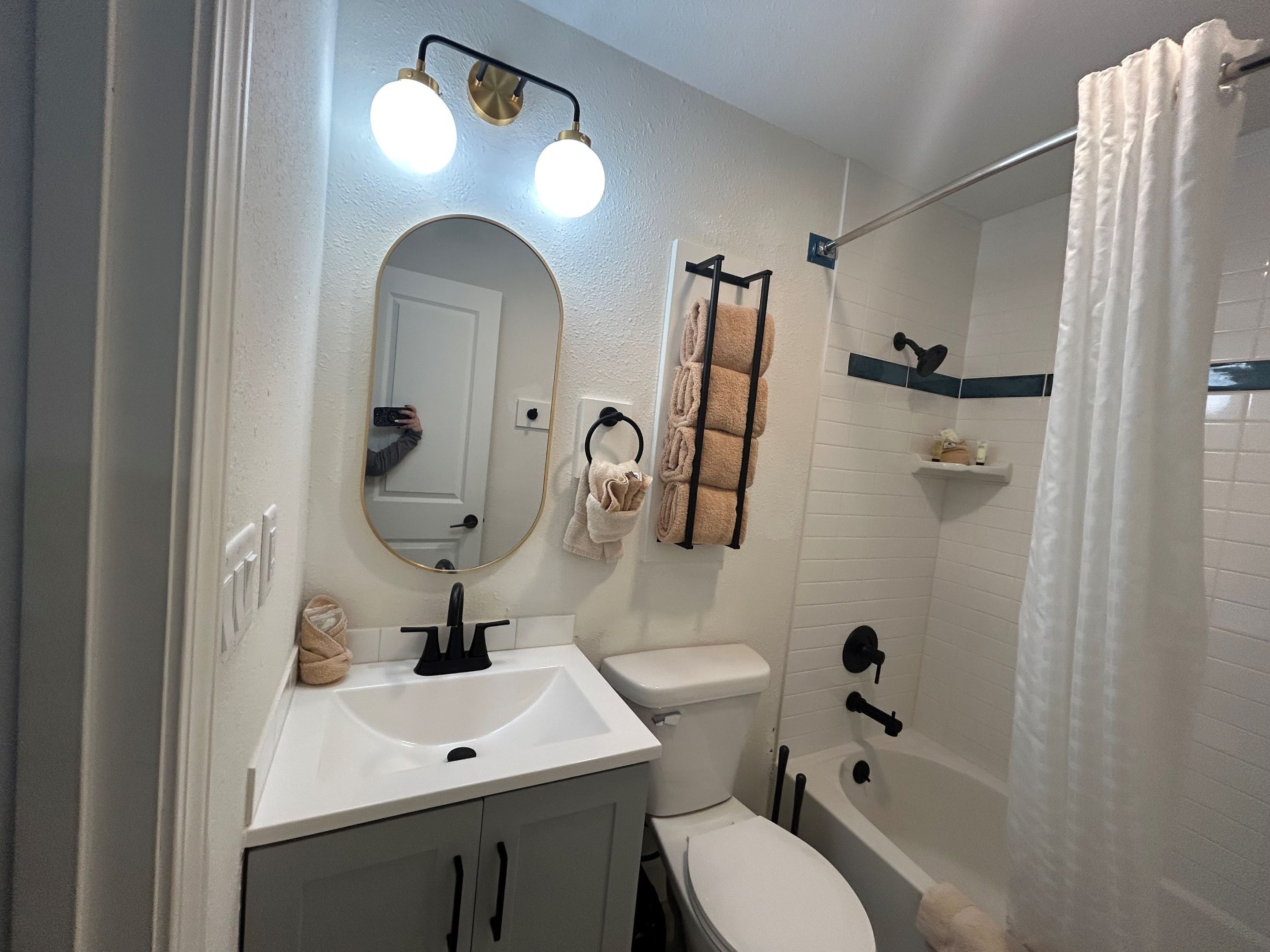 A bathroom with a white sink, a toilet, a bathtub, and a shower curtain.