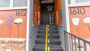 A staircase with a speed limit sign, numbers 1612 and 1610 on the walls, and a brick base. - Chic Getaway Downtown Hub Luxe Linens Near Transit (Redding)