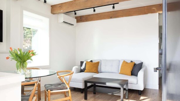 A modern living room with a sofa, coffee table, and dining area. - Romantic modern condo by the lake (Bellevue)