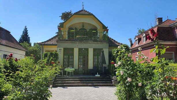 A building with a balcony, a green door, and a number 42 on the wall. - Studio near the beach with internet (Siófok)