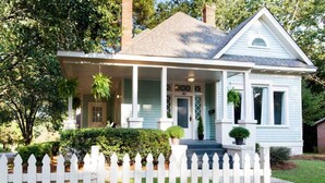 A light blue house with a porch, white picket fence, and potted plants. - Three king beds. One place for everyone to land. Come back from the tournament, graduation, or family visit, spread out, sleep incredibly well, and wake up ready for Montgomery again. (Montgomery)