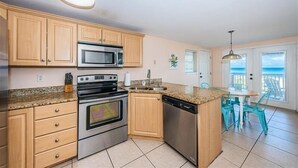 A kitchen with wooden cabinets, stainless steel appliances, and a granite countertop.