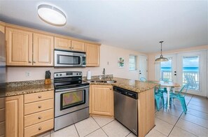 Enjoy meals in the kitchen with modern appliances and dining area overlooking the ocean.