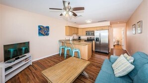 A modern apartment with a kitchen, dining area, and living room.