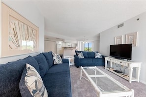 Ein modernes Wohnzimmer mit zwei Sofas, einem Couchtisch und einem Fernseher.