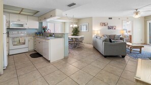 A compact living space with a kitchenette, dining area, and a sofa in the living room.
