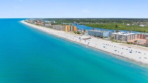 Ein Küstenhotel mit Blick auf den Strand, mehreren Stockwerken und einem Poolbereich.