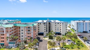 Ein Strandhotel mit mehreren Gebäuden, einem Parkplatz und freiem Blick auf das Meer.