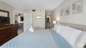 A hotel room with a bed, a dresser, a television, and artwork on the wall. - Beach Palms Premier Gulf Front 3 bedroom condo steps to the Beach~ BP410 (Indian Shores)