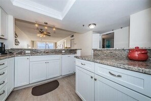 Enjoy cooking in this well-equipped kitchen with a ceiling fan and granite countertops.