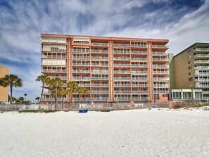Ein mehrstöckiges Hotel mit Balkonen in Strandnähe.