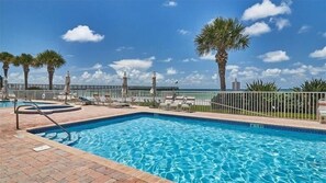 Relax by the pool surrounded by lounge chairs and umbrellas.