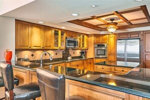 Enjoy cooking in this well-equipped kitchen with a central island, stainless steel sink, and oven.