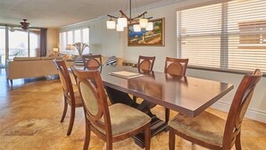 A dining area with a large wooden table, six chairs, and a chandelier. - Luxurious La Contessa Corner unit Directly on the Gulf with Million Dollar Views!~ LC210 (Redington Beach)