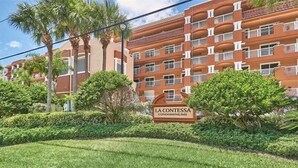 A multi-story building with balconies, surrounded by well-maintained greenery and palm trees. - Luxurious La Contessa Corner unit Directly on the Gulf with Million Dollar Views!~ LC210 (Redington Beach)
